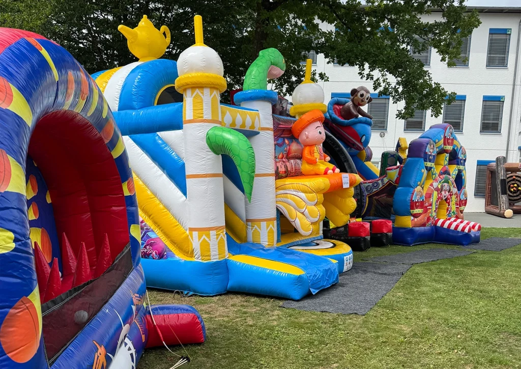 Bunte Hüpfburgen auf einer Wiese mit Kindern