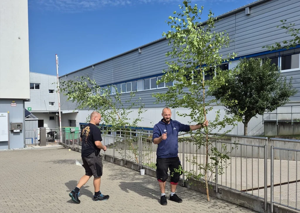 Zwei Männer vor dem Firmengebäude - Sie schmücken alles für die Feier