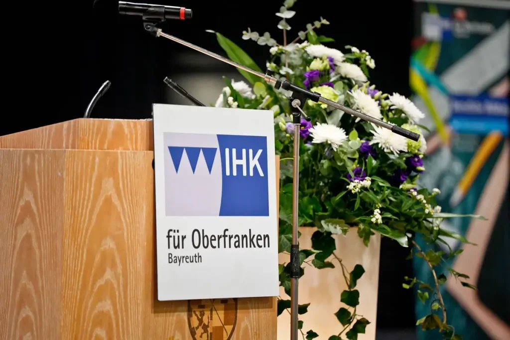 IHK-Rednerpult mit Blumenarrangement.